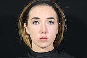 Portrait of a young woman with neutral expression.
