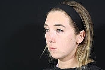 Woman with serious expression against dark background