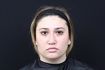 Woman with short hair against a dark background.