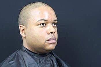 Man with short hair sitting for a haircut.