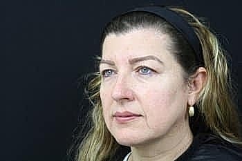 Woman with light hair against black background