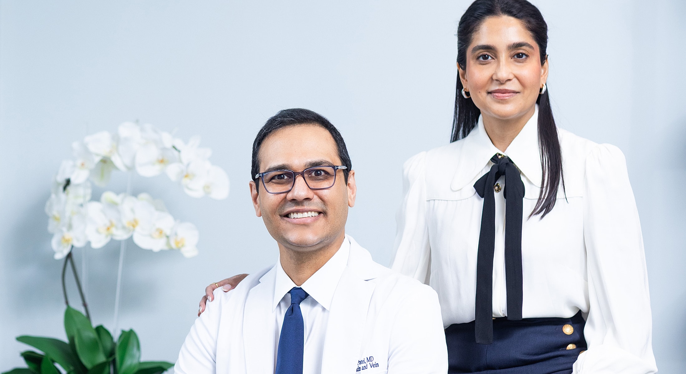 Doctors posing with flowers in medical office.
