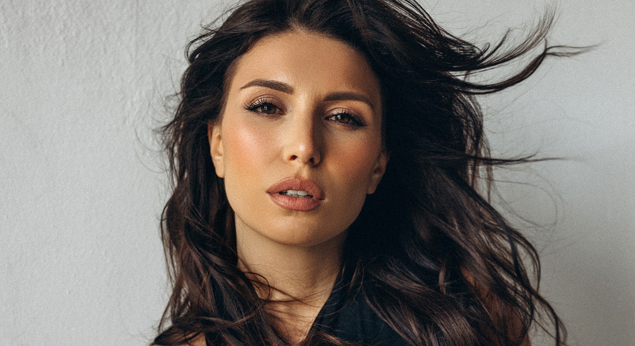 Woman with flowing hair against a light background.