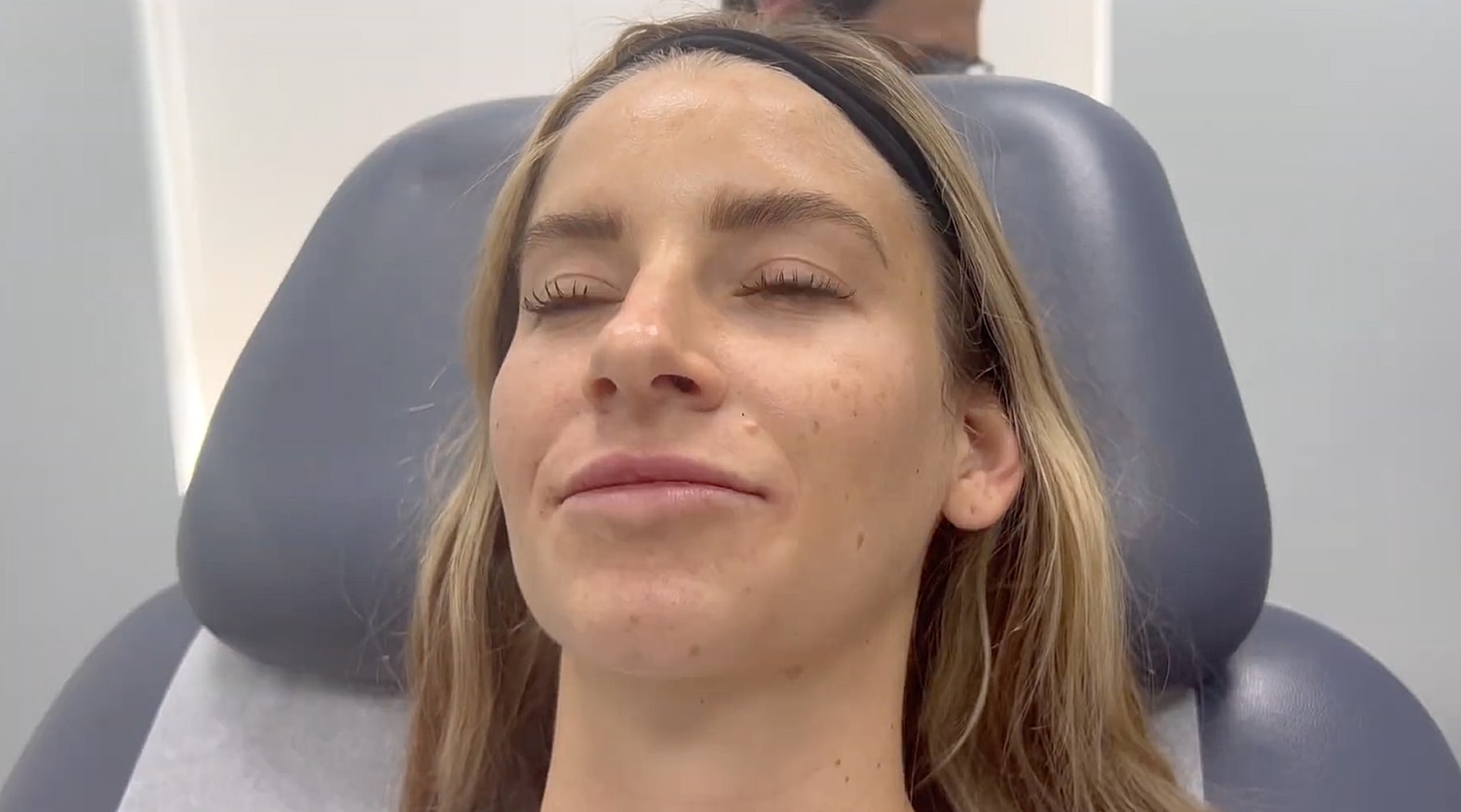 Woman receiving skincare treatment in clinical setting.