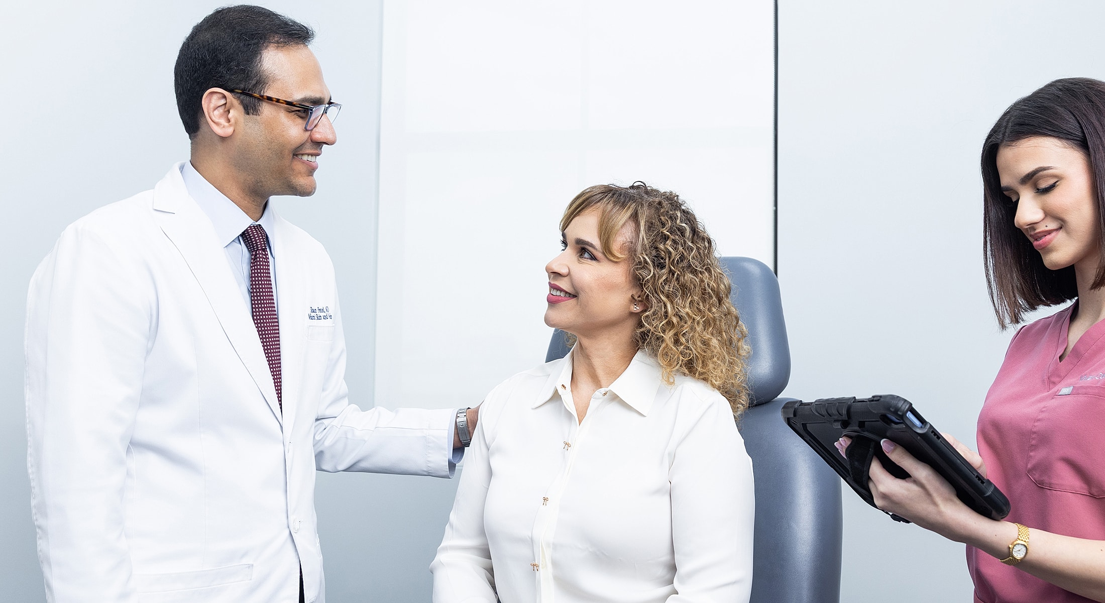 Doctor consulting with patient, nurse taking notes.