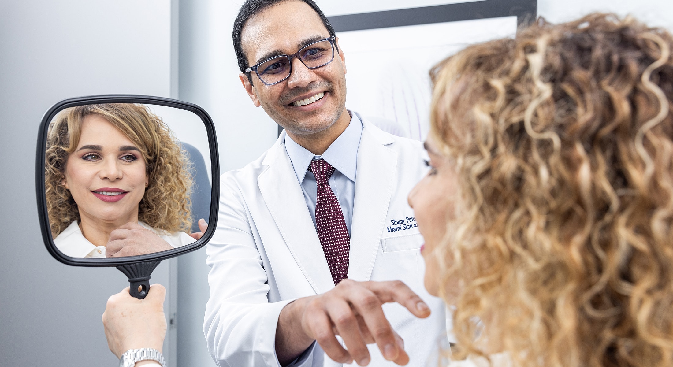 Doctor consulting with patient in mirror reflection.