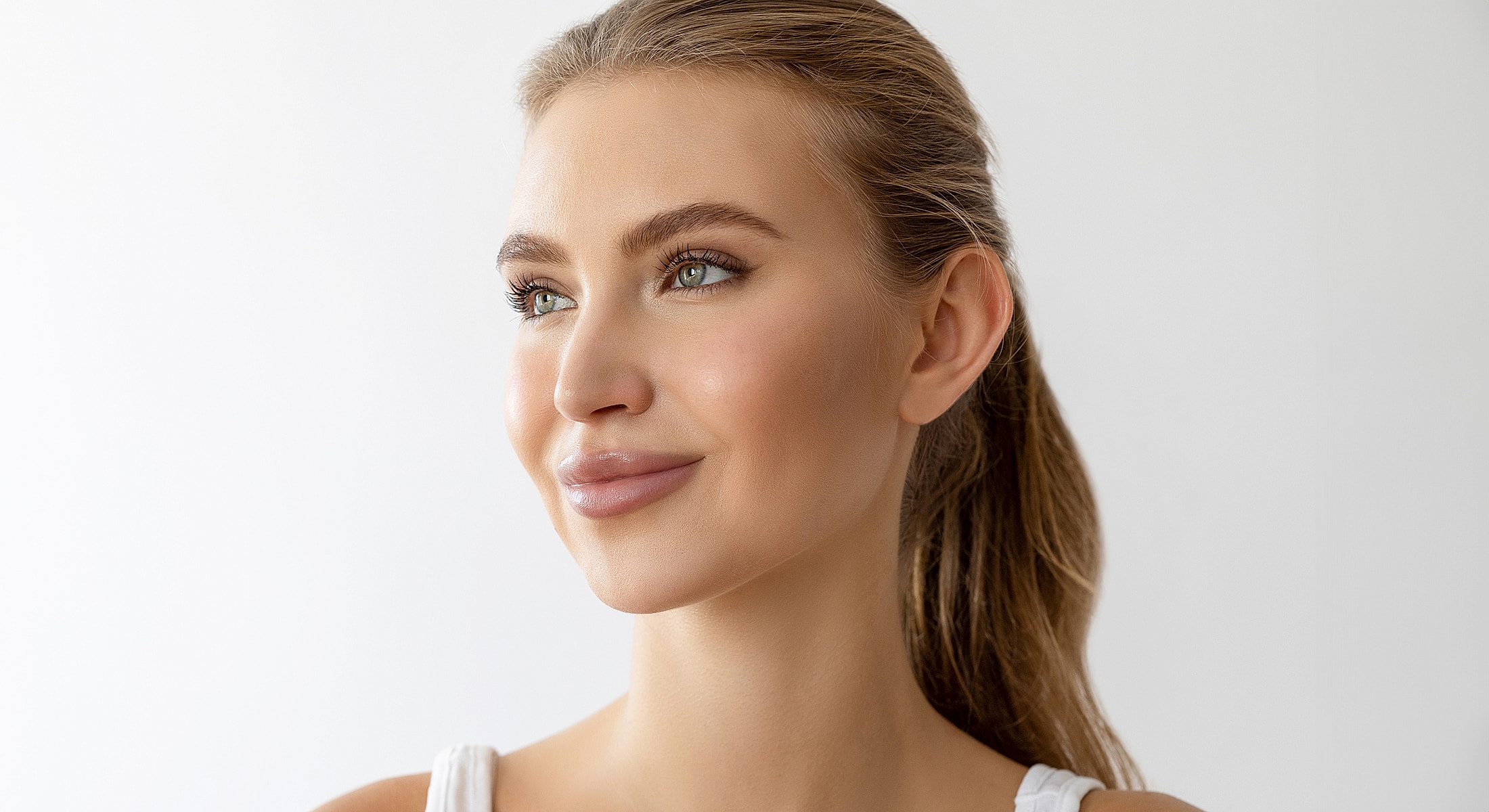 Young woman smiling against a white background.
